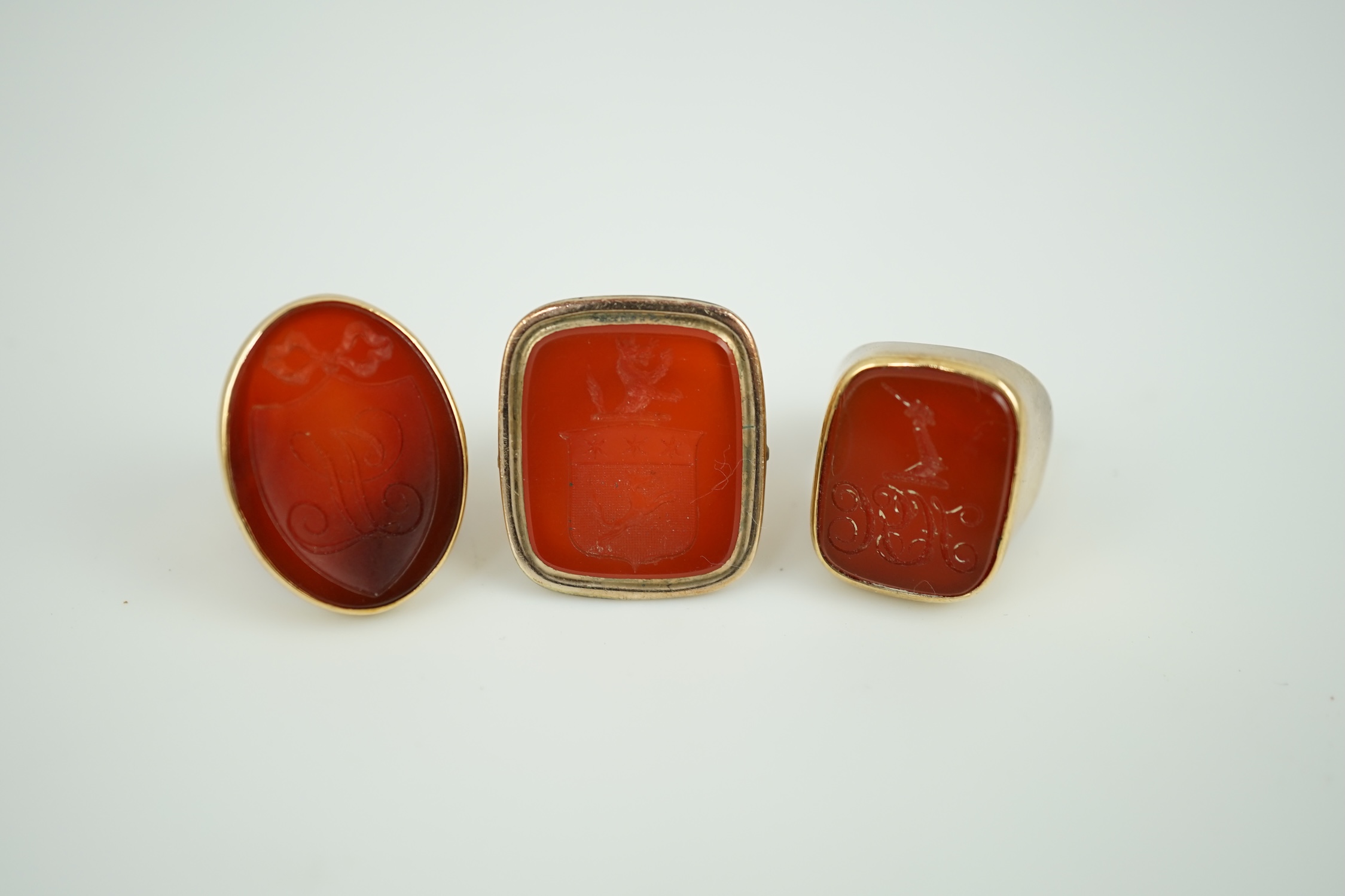 A Victorian 9ct and carnelian set intaglio ring, carved with a crest size L and two other similar yellow metal and carnelian intaglio ring, gross weight 35.8 grams.